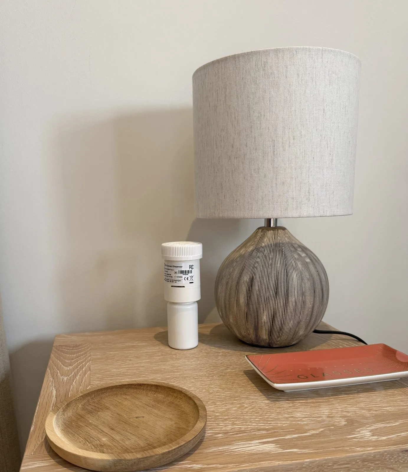 Pill Connect dispenser beside a lamp on a patient's bedside table